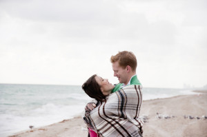 couple wrapped in blanket on beach