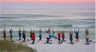 ladies doing yoga on the beach