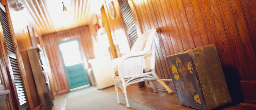 Upstairs hallway of the Inn with a vintage brown suitcase and white chair