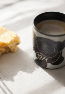 a piece of cornbread with a decorative black coffee cup dated from 1971