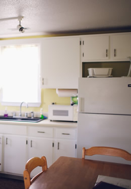 cottage kitchen with white cabinets and refrigerator