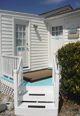 two white steps leading up to the aqua painted porch and front door of cottage